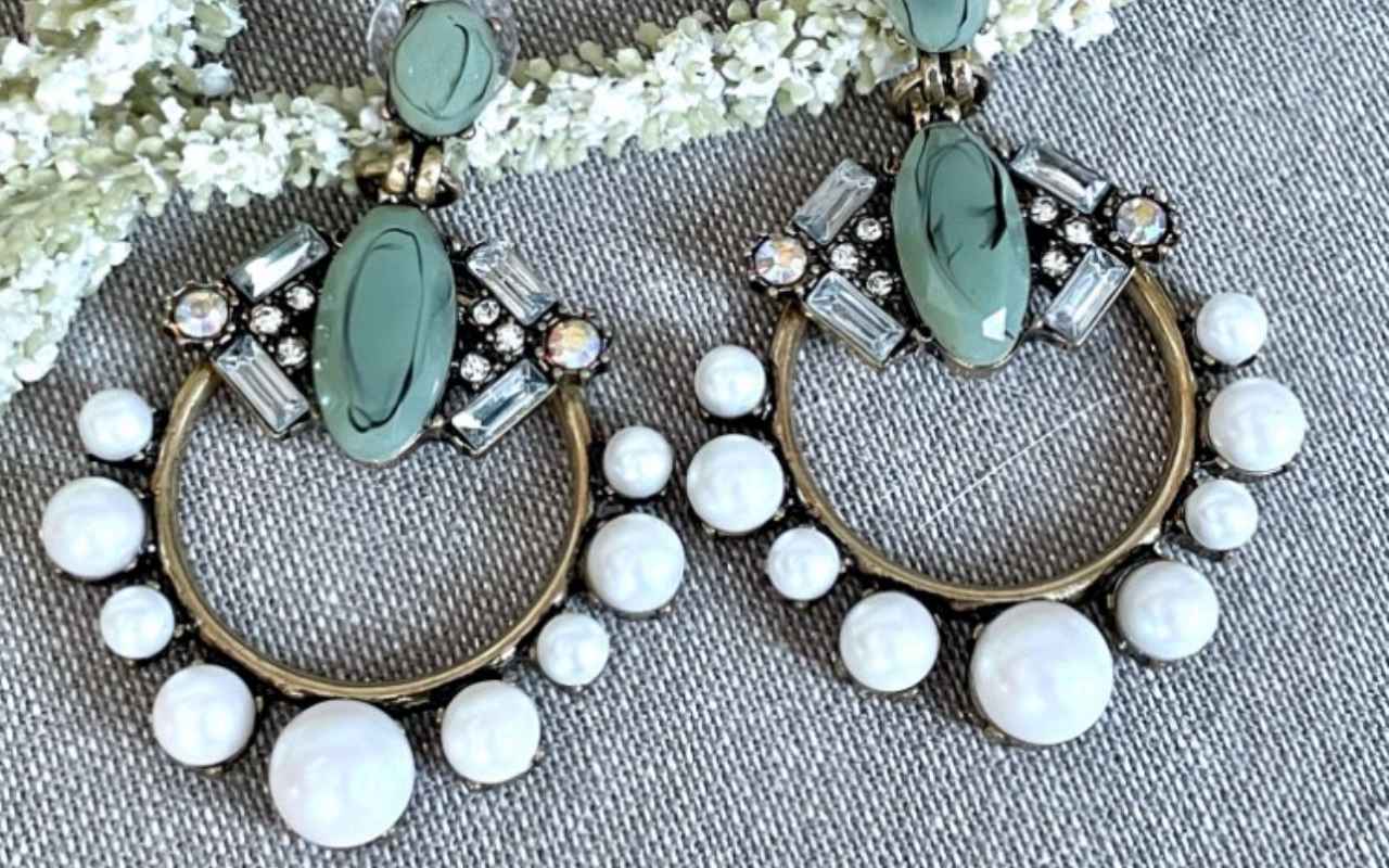 Close up picture of Antique gold alloy Earrings with Large resin stone and faux pearl detailing