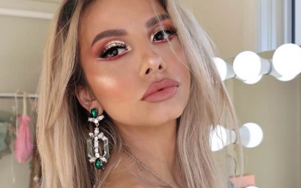 Pretty blonde model with makeup wearing large acrylic statement earrings