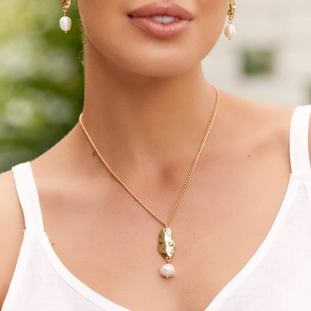 Absract gold plated pendant and freshwater pearl necklace on model