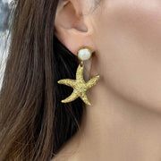 Baroque pearl stud statement earrings featuring textured gold starfish drop