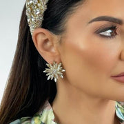Model wearing Gold Alloy and Diamante earring in the shape of a flower or fireworks