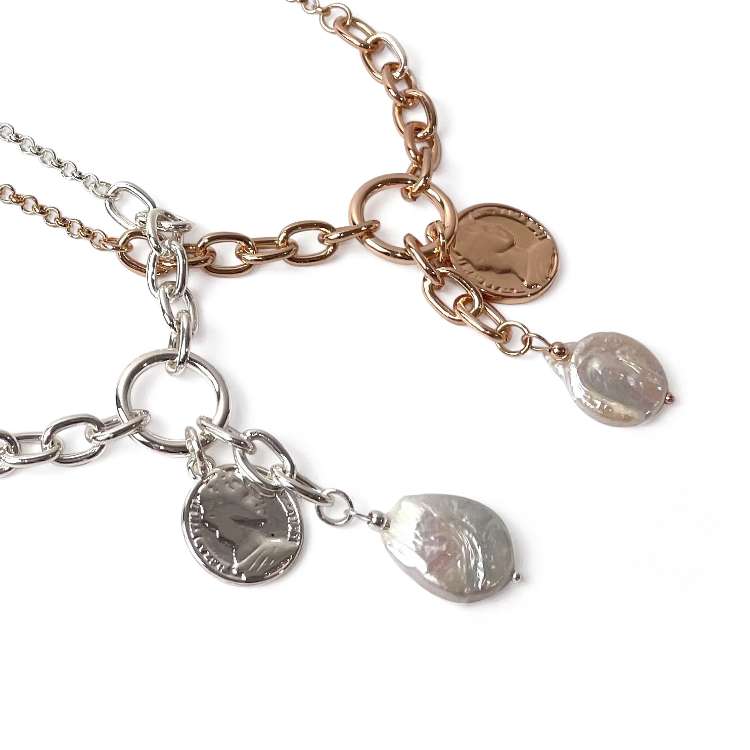 Close up of Graduated chain necklace with Coin and freshwater pearl charm in gold and silver