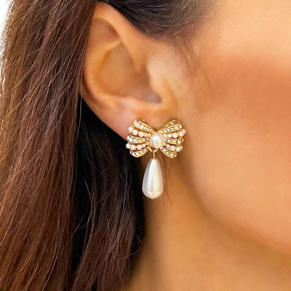 Close up of model wearing Gold and diamante bow stud with Pearl drop