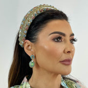 Model wearing Luxurious crepe fabric padded headband Heavily jeweled in opal blue and blush rhinestones and diamante earrings