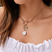 Model wearing Graduated chain necklace with Coin and freshwater pearl charm in gold