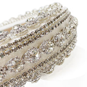 Close up of White fabric padded headband  Heavily embellished in diamante and rhinestones
